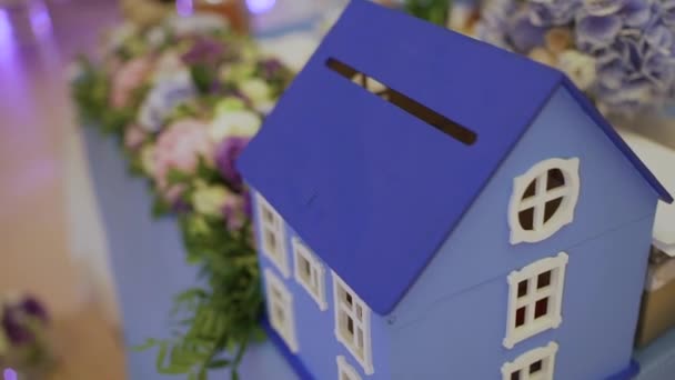 Casa giocattolo sul tavolo con fiori freschi — Video Stock