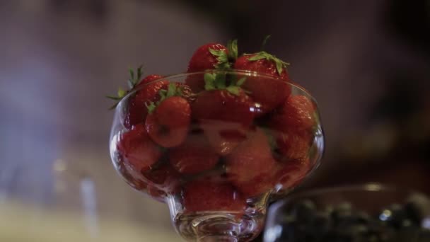Aardbeien in een glas op een tafel — Stockvideo