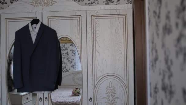 Чоловіча куртка висить на вішалці в кімнаті — стокове відео