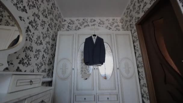 Uma jaqueta de homem pendura em um cabide na sala — Vídeo de Stock