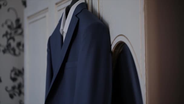 Una chaqueta de hombre cuelga de una percha en la habitación — Vídeo de stock
