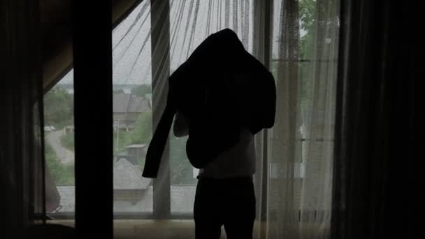 Mann zieht Hemd an, steht zu Hause am Fenster, Zeitlupe. — Stockvideo