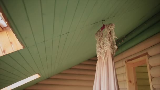 Wedding dress hanging in front of the window — Stock Video