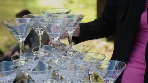 Las manos de los invitados toman vasos con vino burbujeante en la fiesta. Los vidrios están construidos en las pirámides. No hay personas reconocibles . — Vídeo de stock