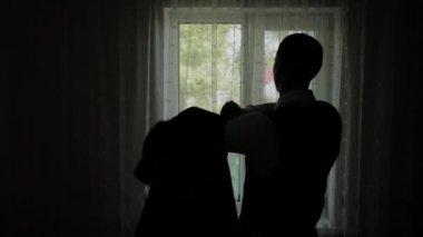 Evde, cam kenarında duran tişörtün üstünde ağır çekim koyarak adam.