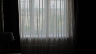 Evde, cam kenarında duran tişörtün üstünde ağır çekim koyarak adam.