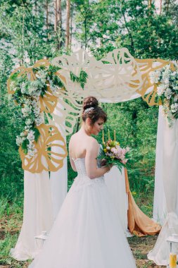 Gelinlik üzerinde taze çiçekler, poz ve portre ile dekore edilmiş bir photozone güzel kadın.