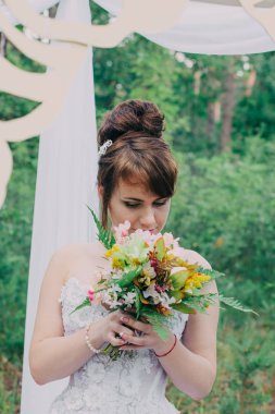 Gelinlik üzerinde taze çiçekler, poz ve portre ile dekore edilmiş bir photozone güzel kadın.