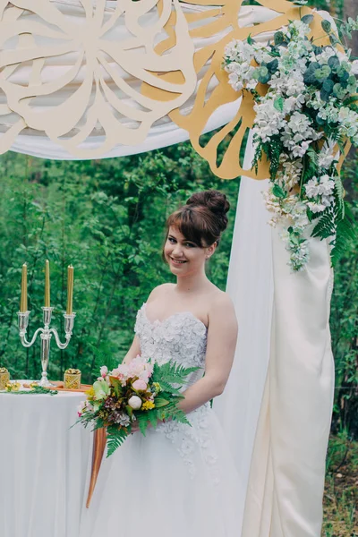 美丽的女人在婚纱礼服上的 photozone 装饰鲜花, 摆姿势和肖像. — 图库照片