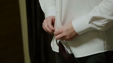 Adam gömleğini takılır