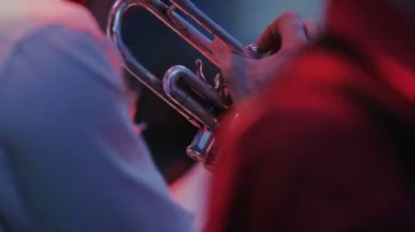 Müzisyenler trompet, gitar ve sax grubun müzikal barda müzik oynuyorlar