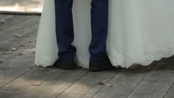Brudgummen och bruden sitter på bron — Stockvideo