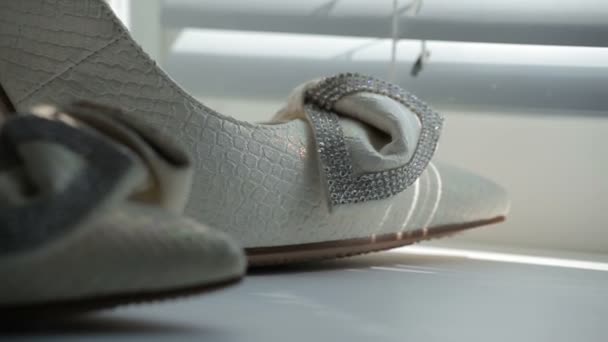 Närbild på en brudar bröllop skor visas på en säng. — Stockvideo