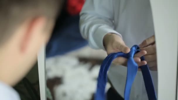 Güzel bir sabitleme bir damat resmini kravat dikkatle, temiz beyaz gömlek üzerinde — Stok video