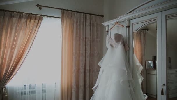 Свадебное платье висит на двери — стоковое видео