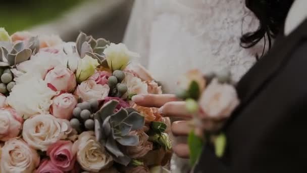 Uma mulher toca um buquê de casamento com a mão — Vídeo de Stock