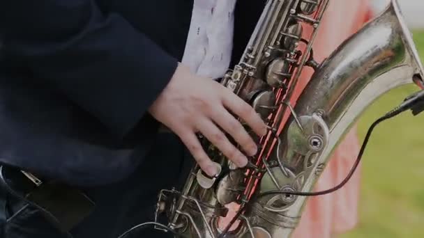 Saxofonista de fato preto toca jazz no saxofone dourado com microfone. Música. Desempenho ao vivo — Vídeo de Stock