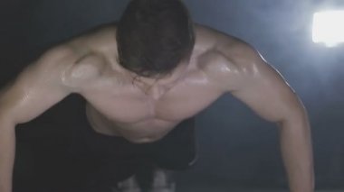 Genç adam spor salonunda ahşap kattan iter