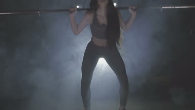 Tam boy görüntü o ağız kavgası gibi bir halter onun omuzlarında ağır ağırlıklar ile tutarak onun gücü test genç bir kadın