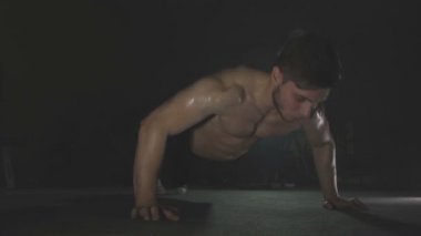 Genç adam spor salonunda ahşap kattan iter