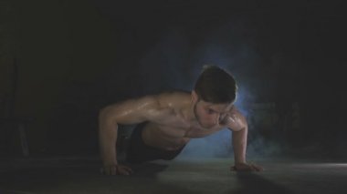 Genç adam spor salonunda ahşap kattan iter