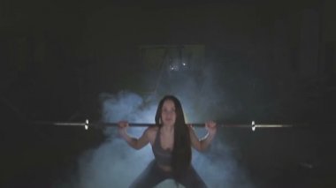 Tam boy görüntü o ağız kavgası gibi bir halter onun omuzlarında ağır ağırlıklar ile tutarak onun gücü test genç bir kadın