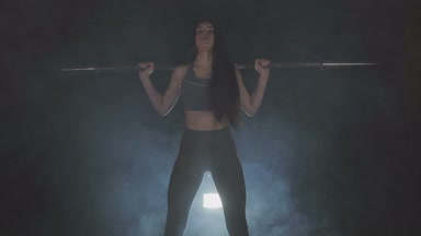 Tam boy görüntü o ağız kavgası gibi bir halter onun omuzlarında ağır ağırlıklar ile tutarak onun gücü test genç bir kadın