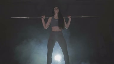 Tam boy görüntü o ağız kavgası gibi bir halter onun omuzlarında ağır ağırlıklar ile tutarak onun gücü test genç bir kadın