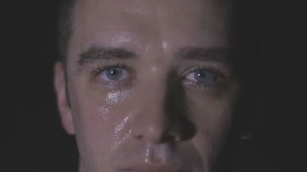 Visage transpirant intense de jeune homme musclé tirant la corde 