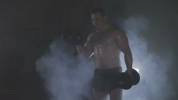 Silne sportowca podnoszenia ciężkich hantle w dym — Wideo stockowe