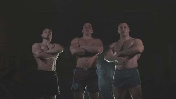 Bodybuilders are three of us, behind the veil dysovaya — Stock Video