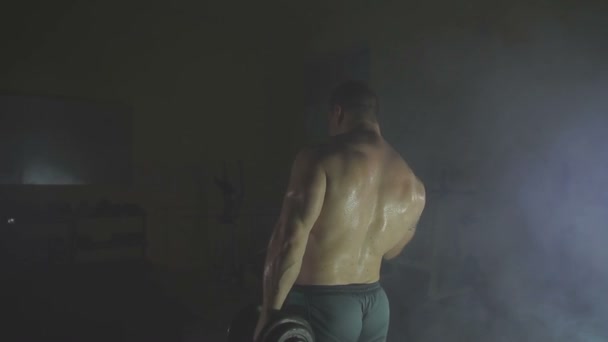 煙で重いダンベルを持ち上げる強いスポーツマン — ストック動画