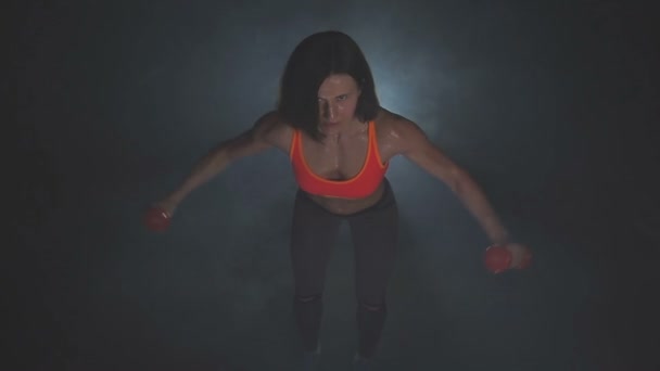 Krásná fitness žena se zvedacími činkami. Sportovní dívka ukazuje své dobře vycvičené tělo. Dobře vyvinuté svaly silovým tréninkem . — Stock video