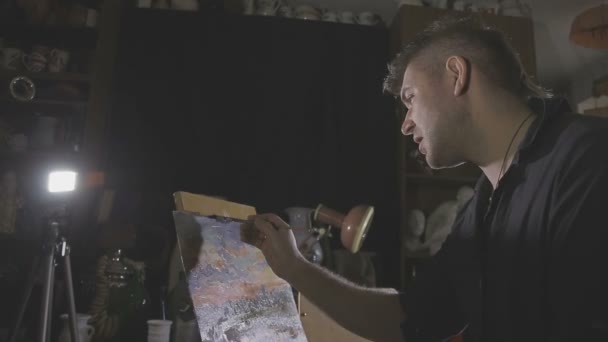 O artista pinta uma pintura no estúdio — Vídeo de Stock