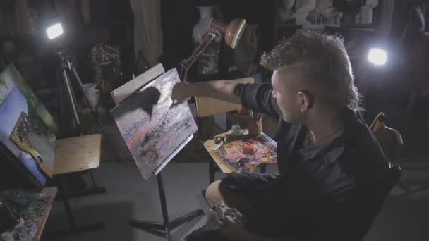 De kunstenaar schildert een schilderij in de studio — Stockvideo