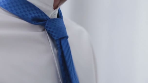 En man binder upp oavgjort med en upphöjd krage, en närbild — Stockvideo