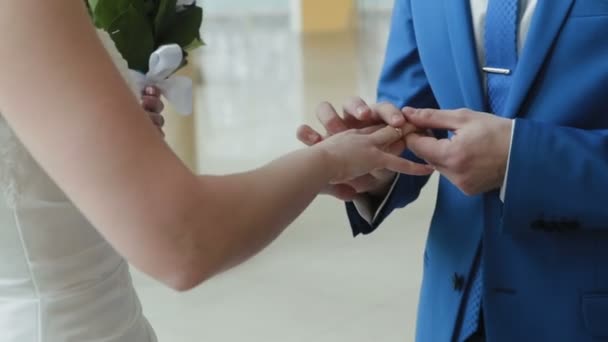 Жених и невеста надевают кольца в свадебном дворце крупным планом — стоковое видео