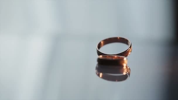 Hermoso vuelo de la cámara a los anillos de boda que se encuentran en la esquina con un recubrimiento barnizado — Vídeo de stock