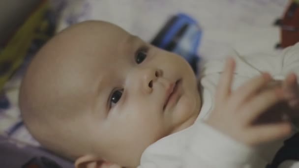 Happy newborn baby yawns closeup in white bed — Stock Video