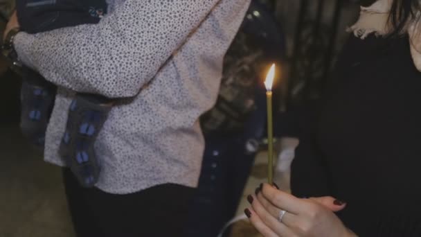 Свеча в руке на таинстве крещения — стоковое видео