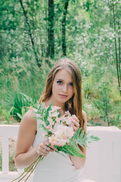 Velmi krásná žena v přírodě obklopen skutečné květiny. — Stock fotografie