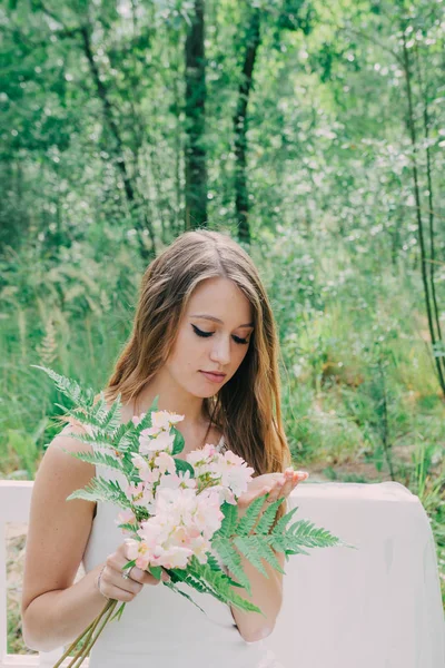 Bardzo piękna kobieta w naturze, w otoczeniu prawdziwych kwiatów. — Zdjęcie stockowe