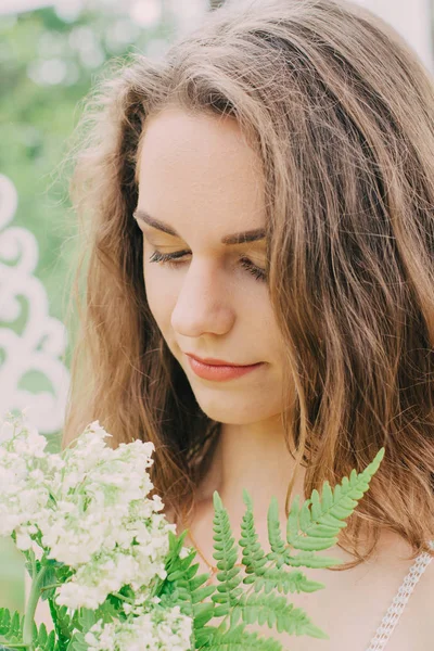 Très belle fille photographiée dans la nature avec des fleurs fraîches . — Photo