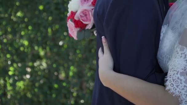 花嫁の手で花束と腰で新郎を抱き締める — ストック動画