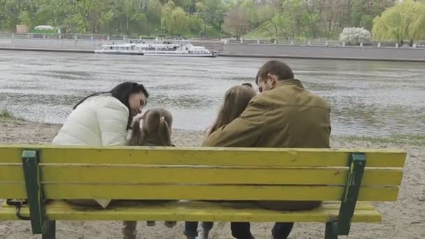 Rodina chodí na břehu řeky v teplém počasí — Stock video