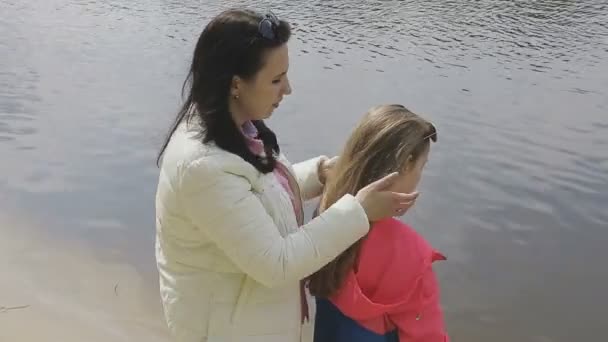 Familjen går på flodbanken i varmt väder — Stockvideo