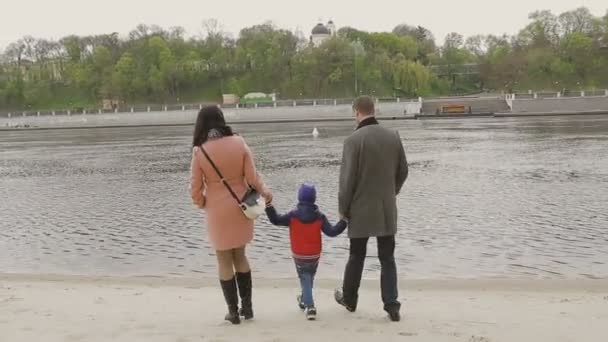 Familie wandelingen aan de rivieroever in warm weer — Stockvideo