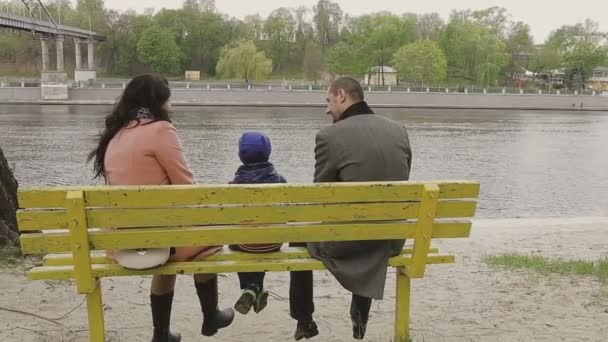 Rodina chodí na břehu řeky v teplém počasí — Stock video