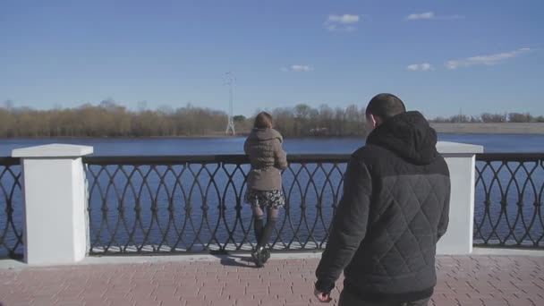 Любящая пара прогуливается вдоль реки — стоковое видео