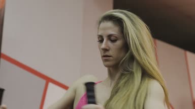 Çok güzel kadın eğitmen trenler bir fitness kulübünde fitness makinedeki